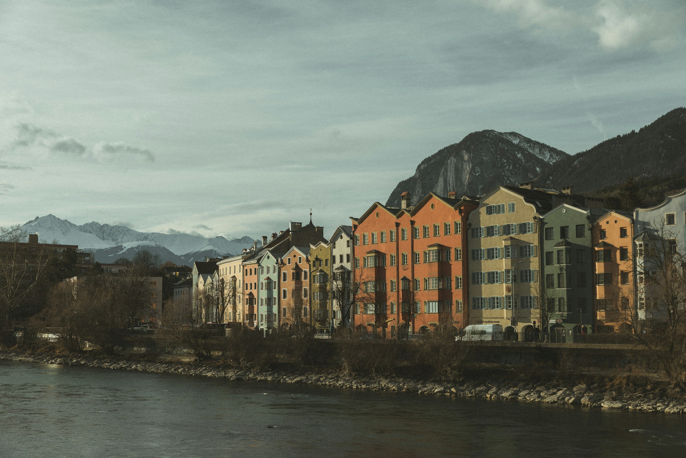 A river running through a city next to tall buildings by Florian Schindler