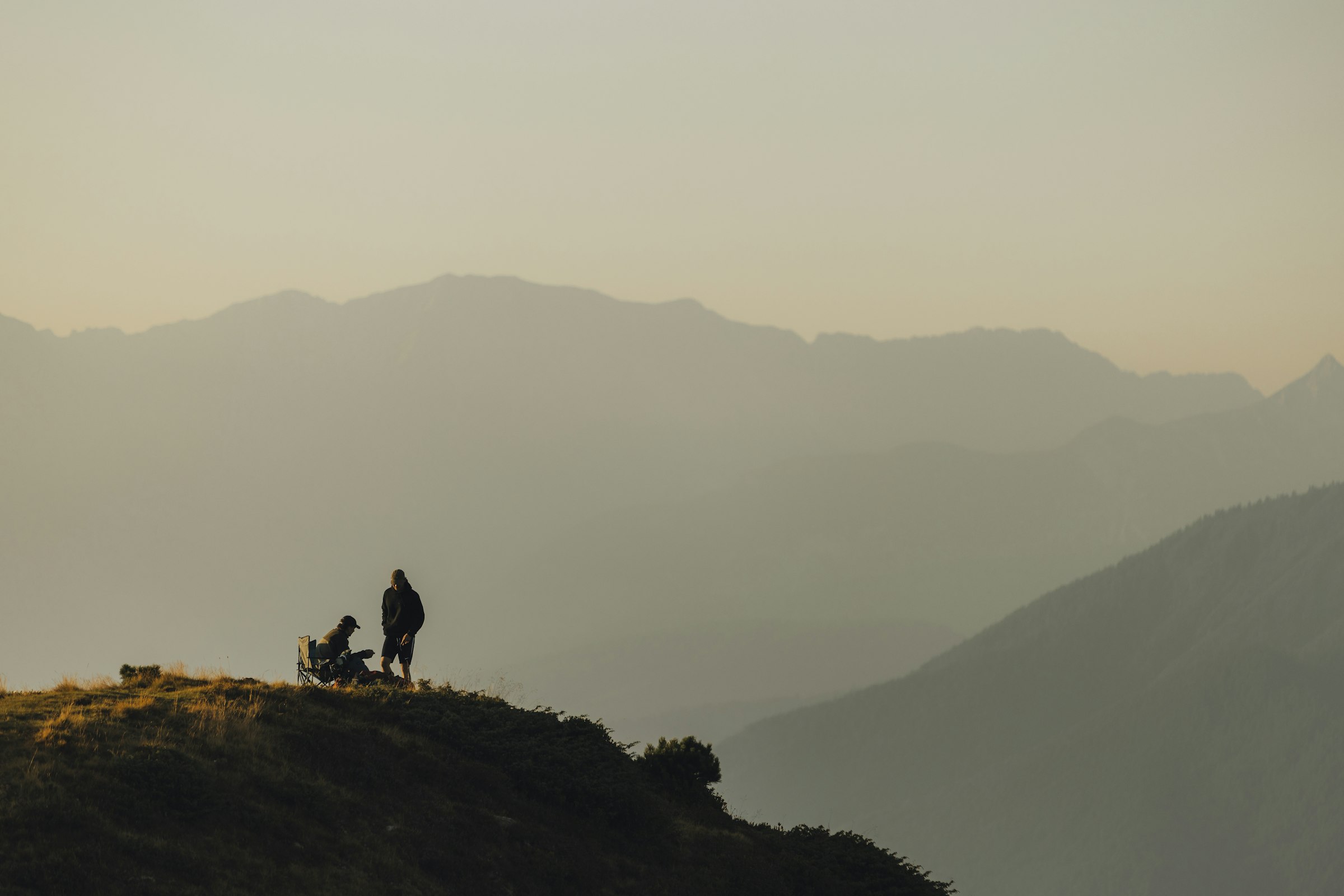 Silhouettes of people on a mountain ridge at sunset by Florian Schindler