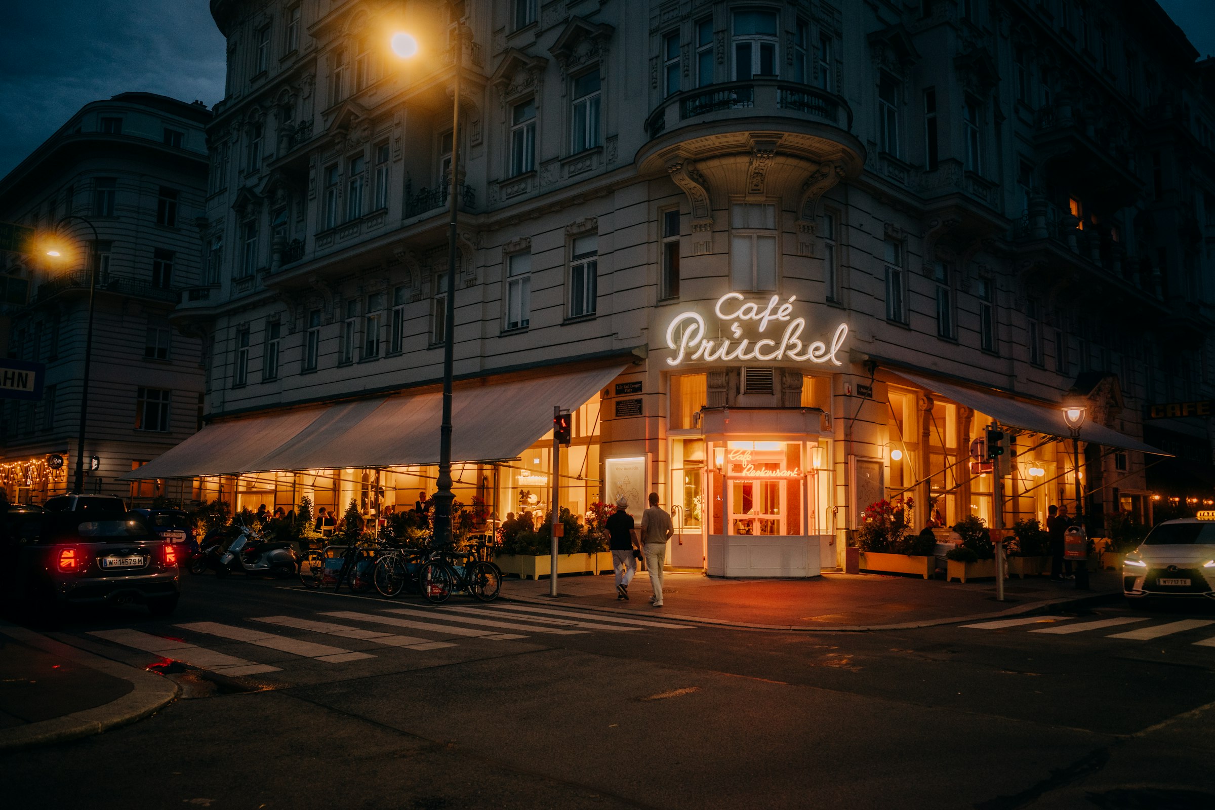 Café Prückel illuminated at night on a city corner by Florian Schindler