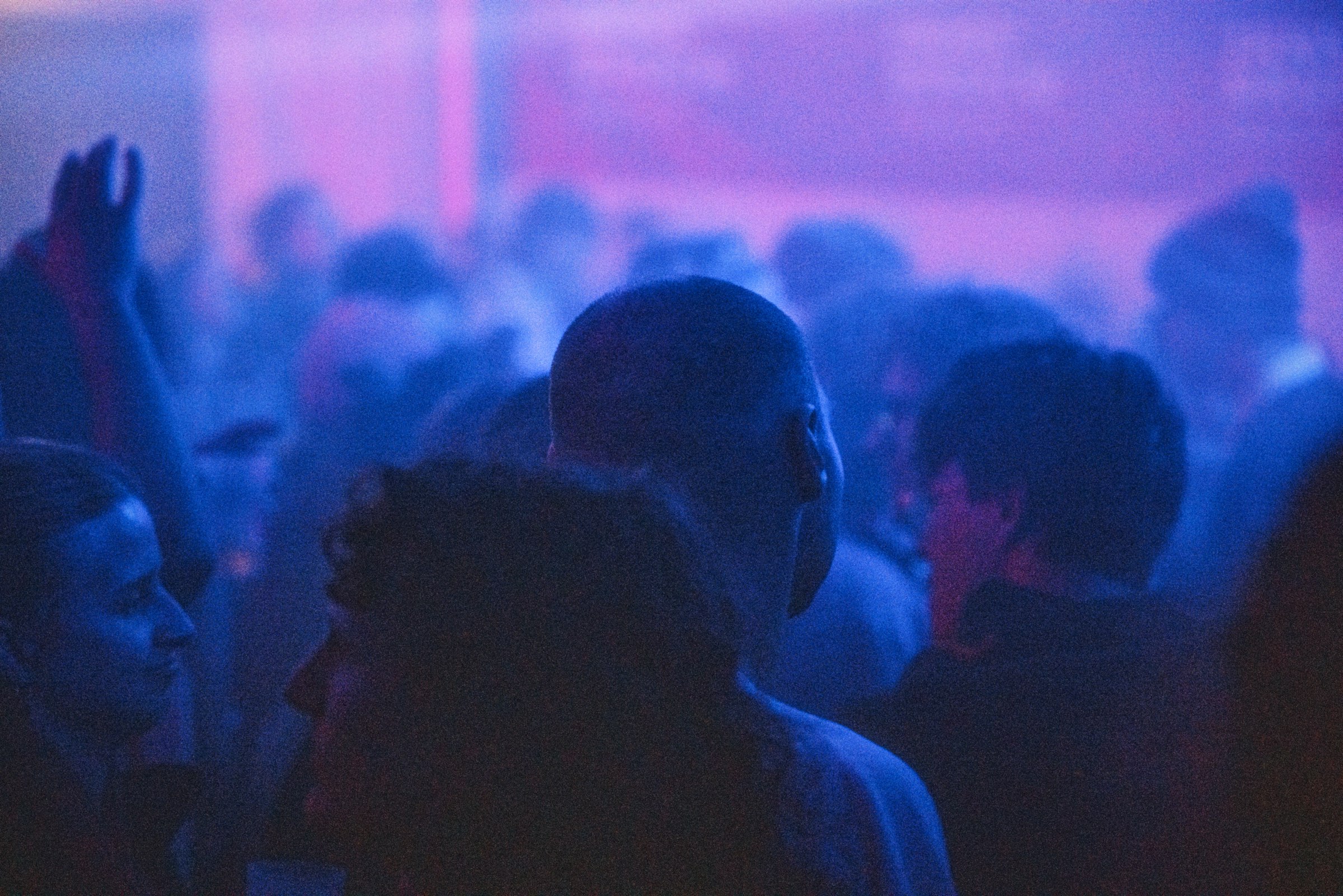 Crowd under vibrant blue and purple club lights by Florian Schindler