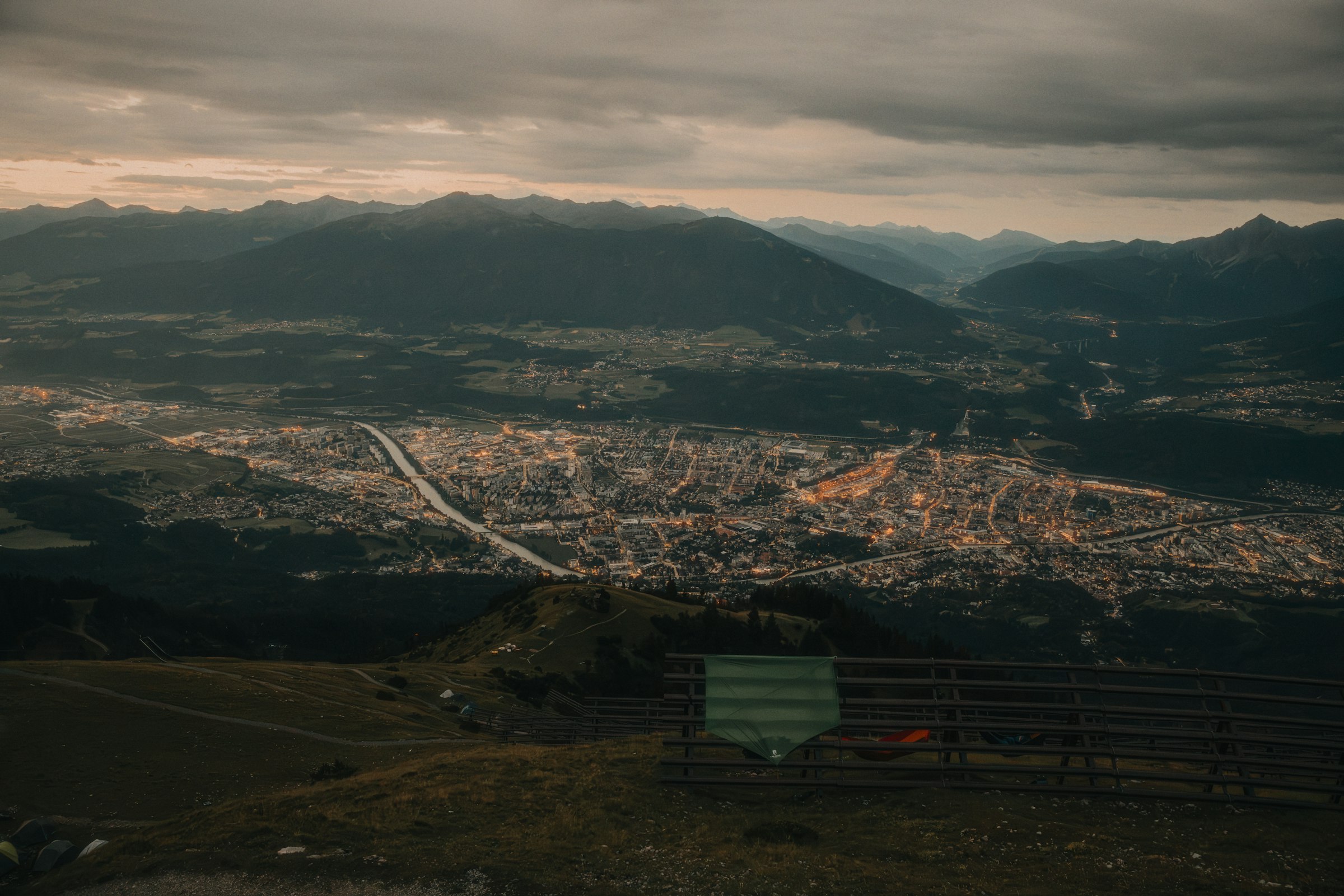 A city in a mountain valley under a cloudy sky by Florian Schindler
