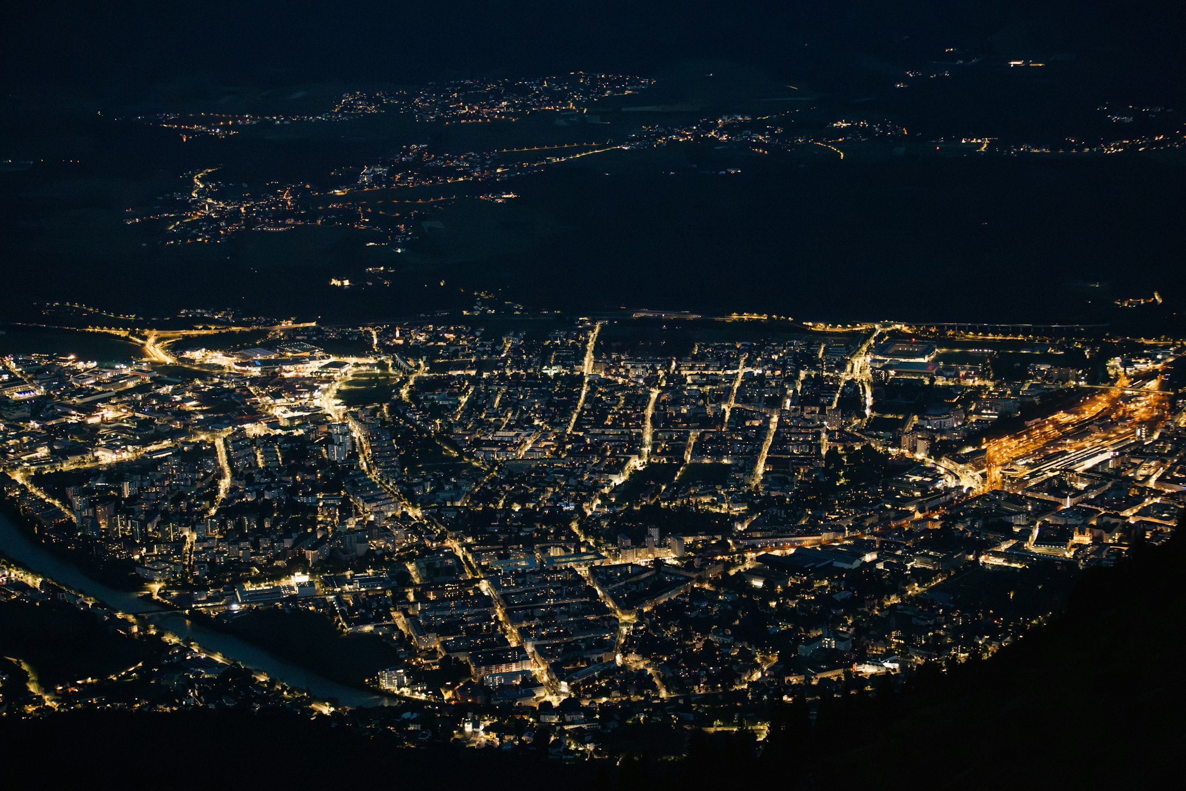 Nighttime aerial view of a brightly lit city by Florian Schindler