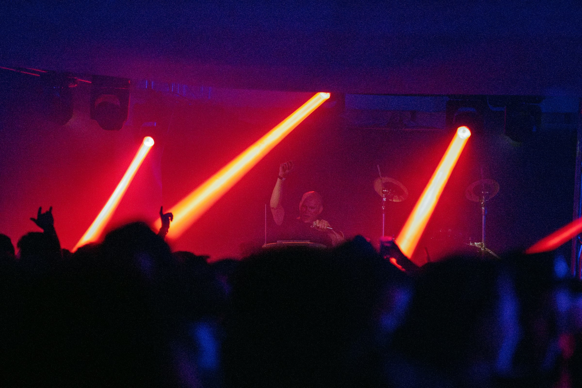 Concert crowd under red stage lights by Florian Schindler