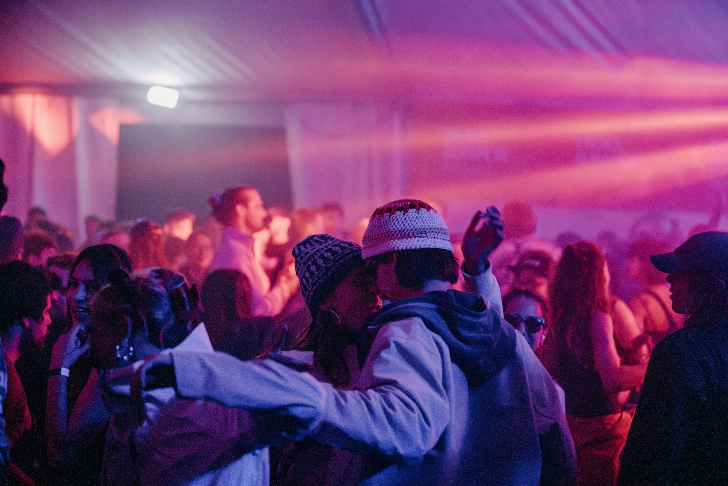 Energetic crowd under pink and purple party lights by Florian Schindler