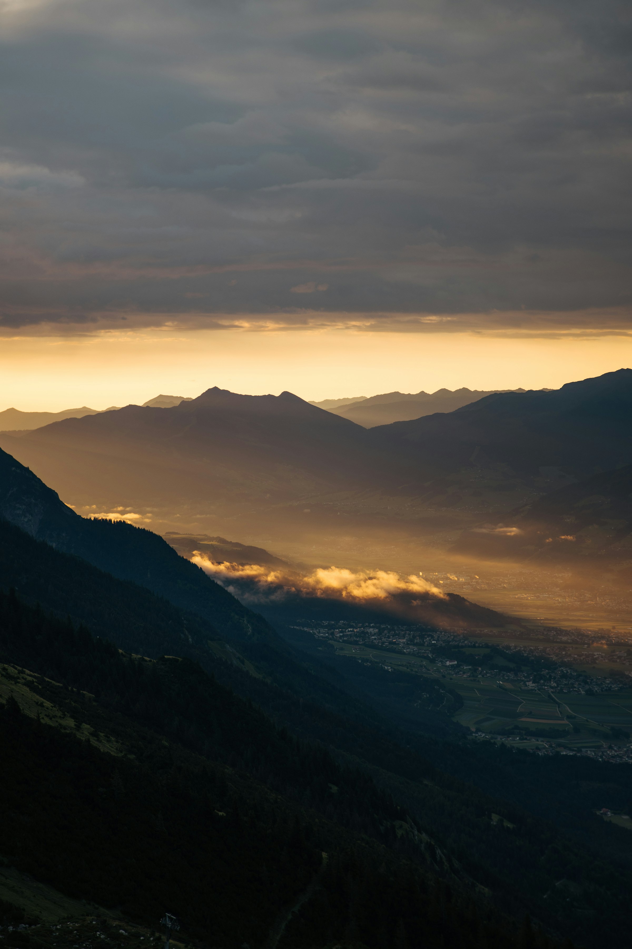 Golden light illuminating a mountain valley at sunset by Florian Schindler