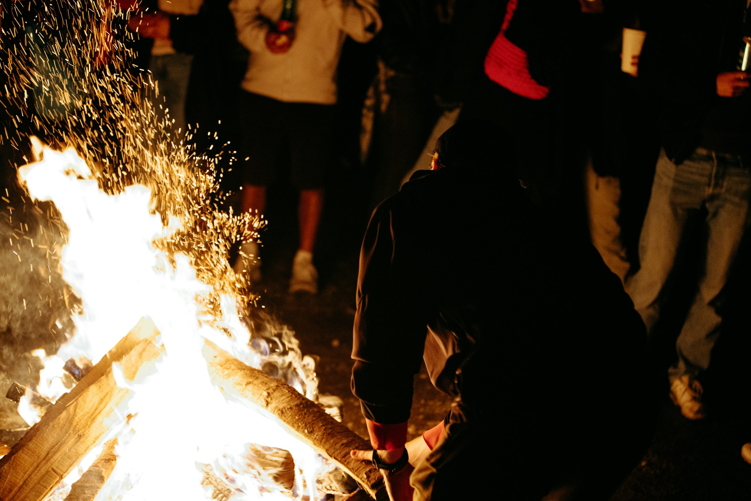 People gathered around a bright bonfire at night by Florian Schindler